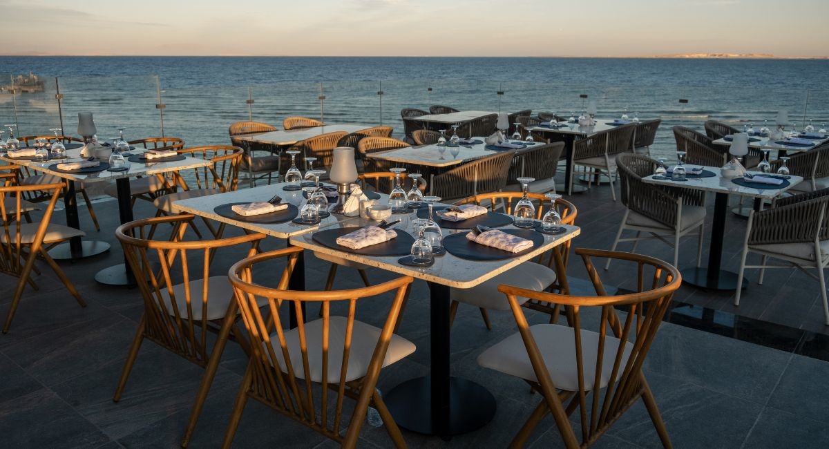 Sunset Dining Tables Set for Ocean View Dinner in Seven Mile Beach